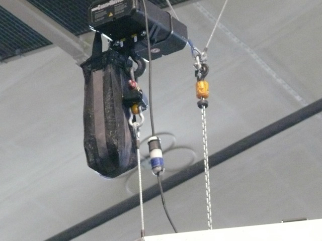 Metallica plays while surrounded by an audience huge speakers hang above the crowd