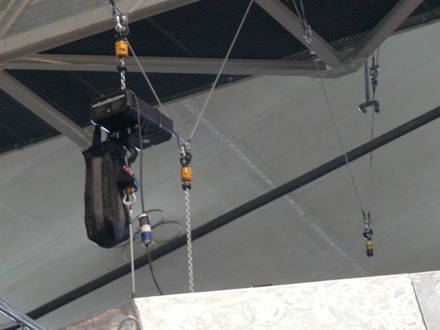 Metallica plays while surrounded by an audience huge speakers hang above the crowd
