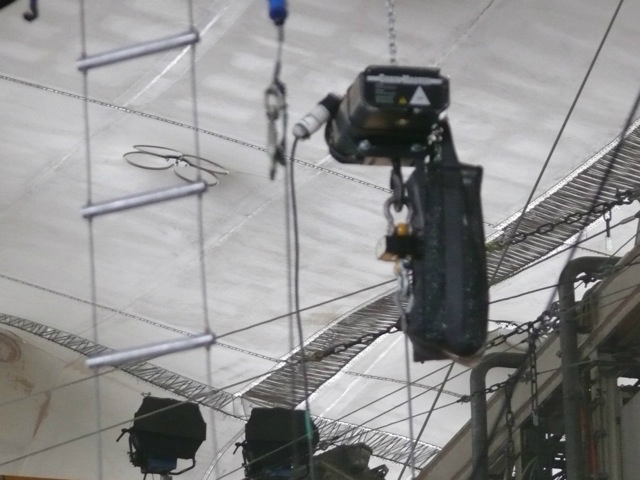 Metallica plays while surrounded by an audience huge speakers hang above the crowd